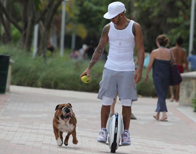 Lewis-Hamilton-takes-his-dog-for-a-walk-while-riding-a-unicycle